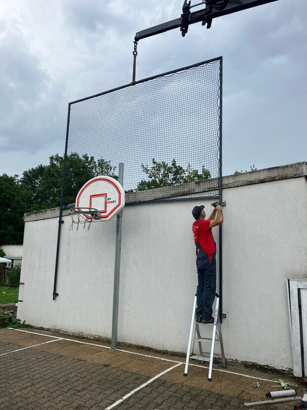 Unser Bauhofmitarbeiter, Herr Frick, installiert das Ballfangnetz 