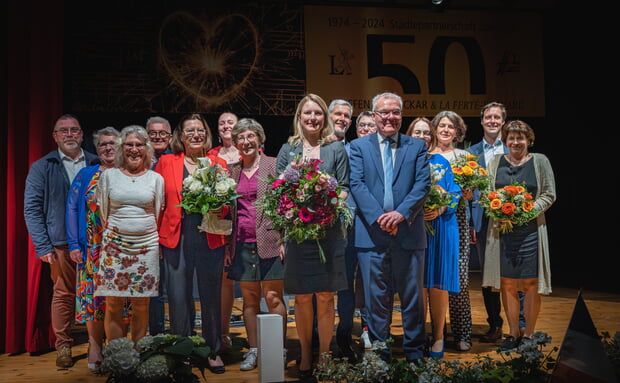 Die Aktiven der beiden Partnerschaftskomitees tragen die Städtepartnerschaft in die Zukunft gestützt durch die Bürgermeister der beiden Städte (vorne Mitte): Sarina Pfründer und Didier Reveau, hier beim Festabend in der Stadthalle. (Foto: Elisa Kullick)