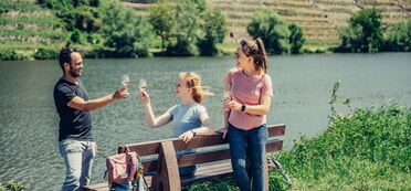 3 Wanderer trinken Wein, im Hintergrund der Neckar und Steillagen-Weinberge